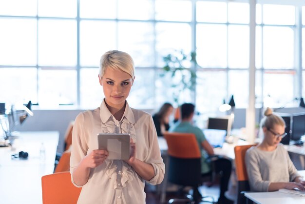 young female entrepreneur working on digital tablet in night office