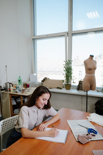 Young female fashion designer working on her designs in the studio