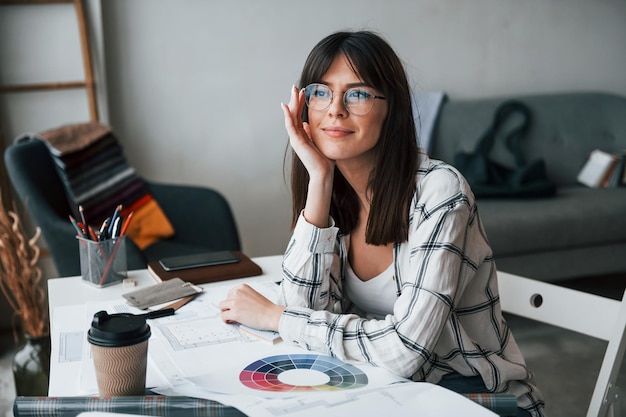 Young female freelance worker is indoors in home at daytime