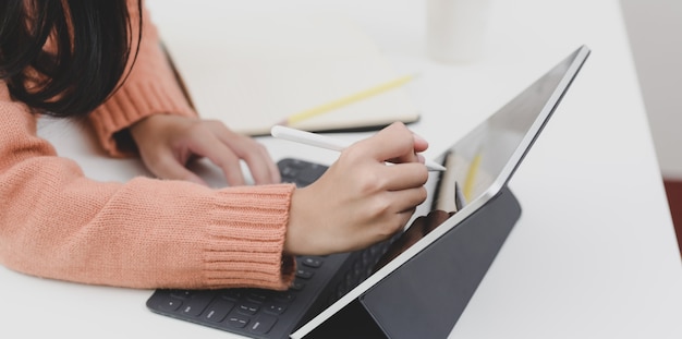 Young female freelancer working on her upcoming project while editing on her tablet