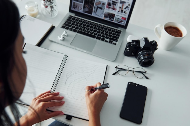 Young female freelancer working indoors in the office at daytime