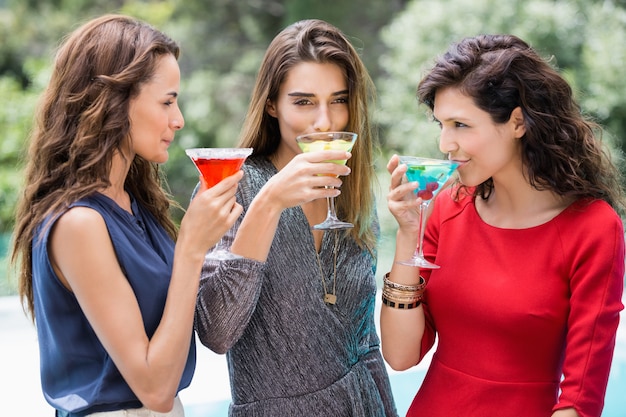 Young female friends drinking cocktail