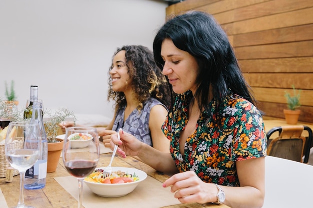 young female friends having food at restaurant