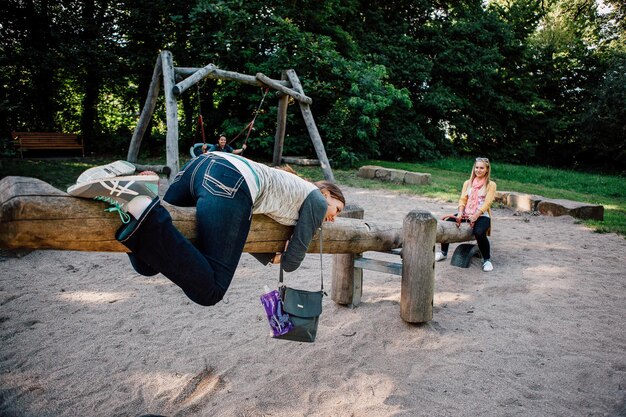 Young female friends playing on wooden seesaw at park