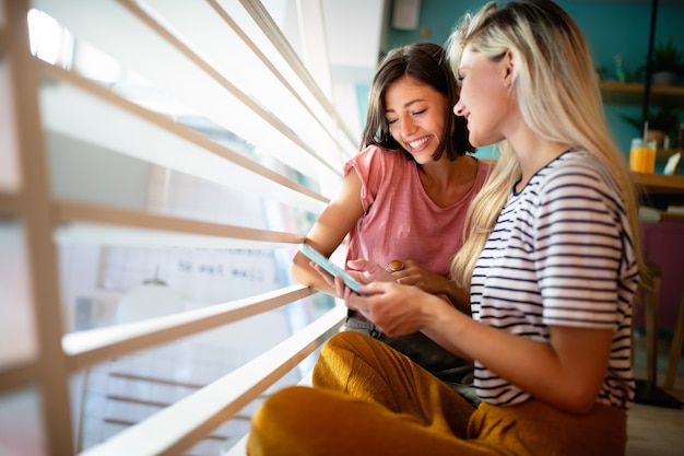 Young female friends surfing the internet and having fun together