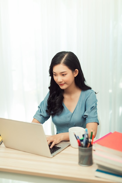 Young female gardener in glasses using laptop, communicates on internet