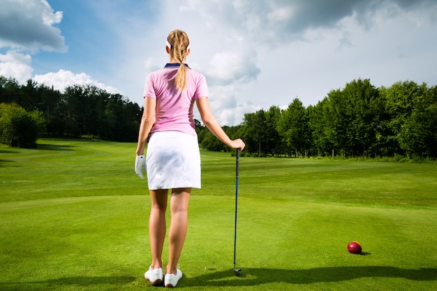 Young female golf player on course