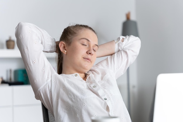 Young female grantee relaxing and stretching in office