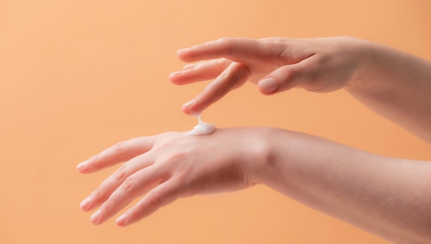 Young female hands applying cream or lotion