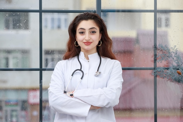 Una giovane operatrice sanitaria ha incrociato le braccia e guardando la fotocamera foto di alta qualità