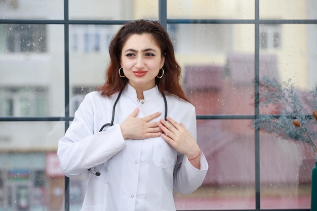 A young female health care worker put her hand to her chest