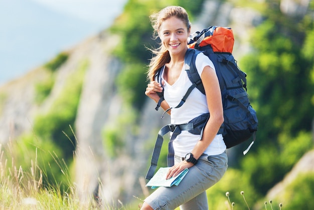 Young female hiker with backpack and map