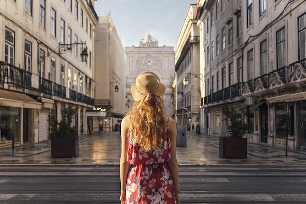 写真 ポルトガル、リスボンの商店街を歩いている花柄のドレスを着た若い女性