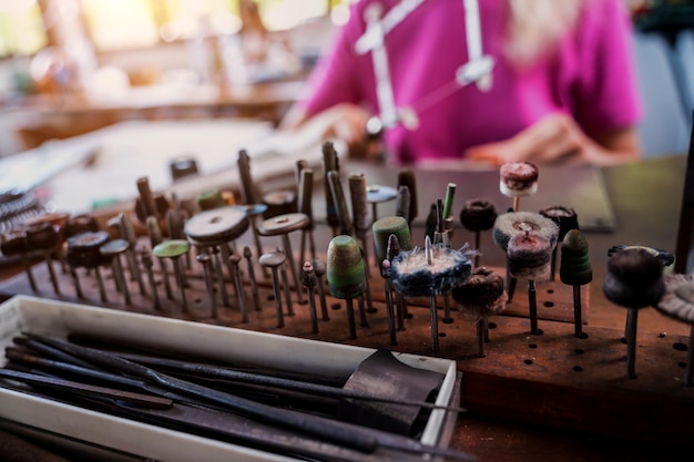 Young female jeweler making jewelry in workshop