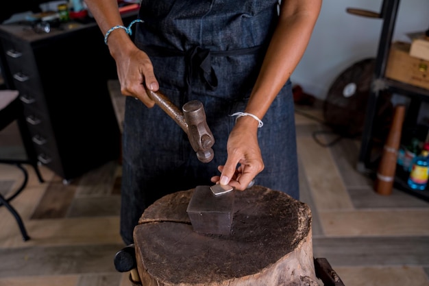 Young female jeweler making jewelry in workshop