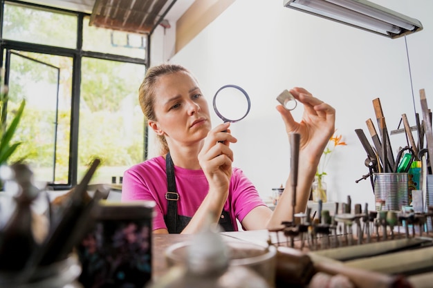 Young female jeweler making jewelry in workshop