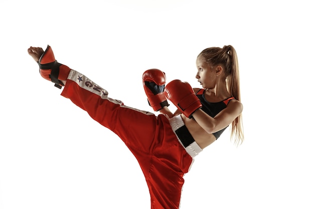 Young female kickboxing fighter training on white