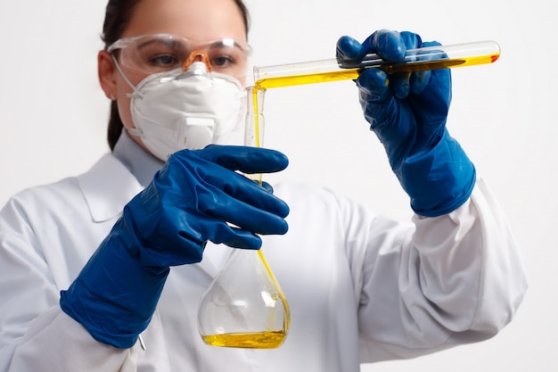 Young female laboratory worker holding test tubes with chemists