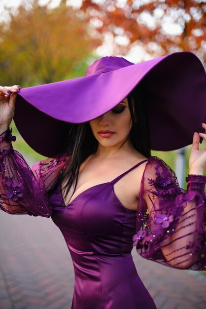 Young Female in luxurious dress is standing in autumn park