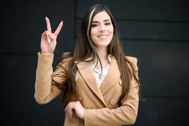 Молодая женщина-менеджер делает знак победы