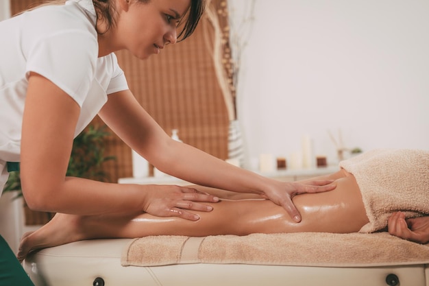 Young female massage therapist giving a relax massage to a client.