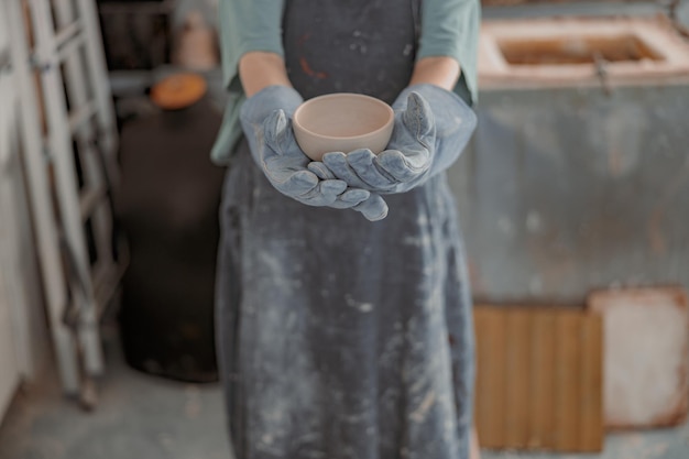 写真 作業室で陶器を扱う若い女性マスター