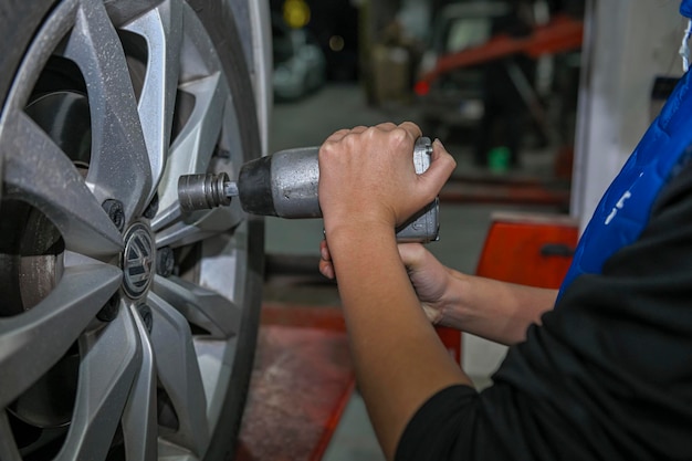 Young female mechanic checking the air pressure of a car's tires