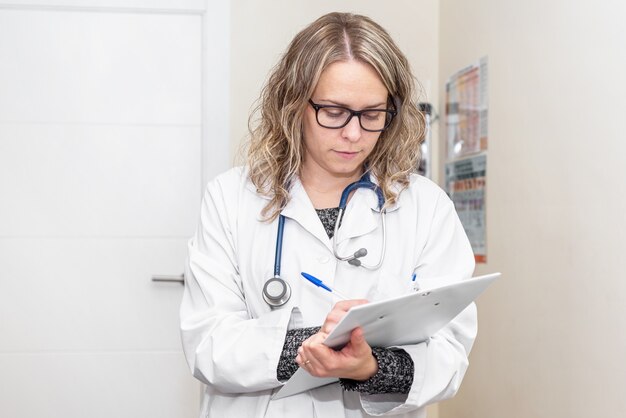 Young female medicine doctor, holding clipboard. Medical diagnosis.