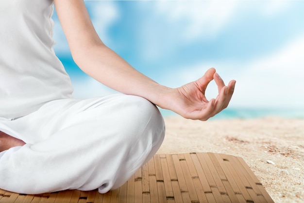 Young female meditation on a sea background