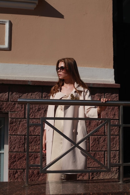 Young female model posing against building