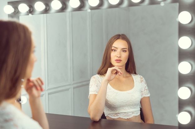 写真撮影の前にスツールに座っている若い女性モデル