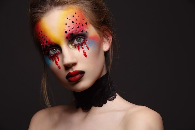 Foto giovane modello femminile con il trucco degli occhi di sangue