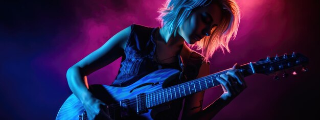 Фото Молодая музыкантка играет на гитаре на рок-концерте