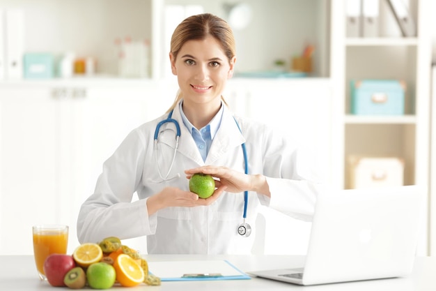 Young female nutritionist working in her office