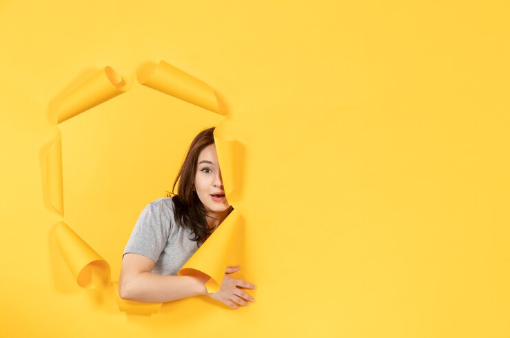 Photo 穿著睡衣的年輕女性透過紙背景廣告窗口的孔子看