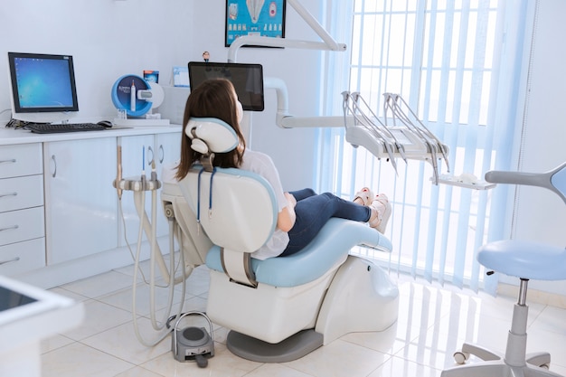 Young female patient sitting on chair in dental clinic