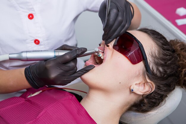 Фото Молодая пациентка с красивой улыбкой осматривает зубы в стоматологической клинике здоровые зубы