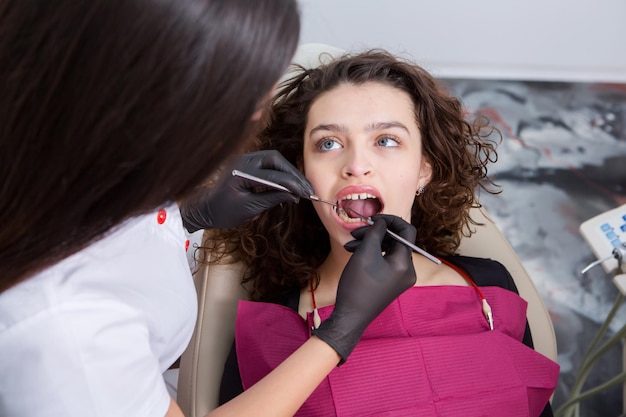 Foto giovane paziente femminile con un bel sorriso che esamina l'ispezione dentale presso la clinica dentistica denti sani
