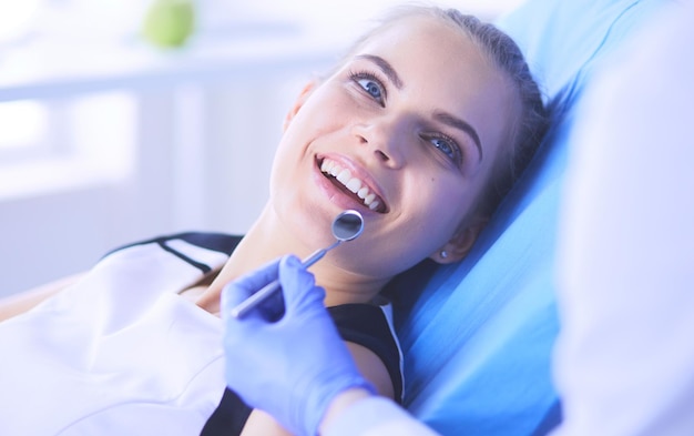 Young Female patient with pretty smile examining dental inspection at dentist office