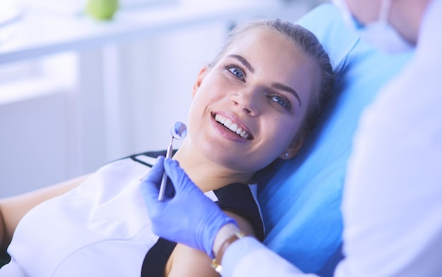 Young Female patient with pretty smile examining dental inspection at dentist office