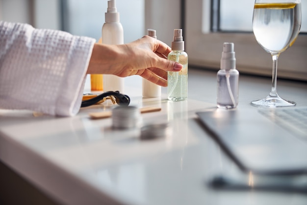 Young female person testing lots of cosmetics