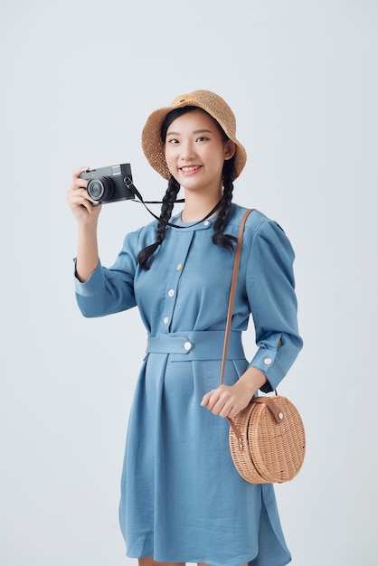 Young female photographer on gray background