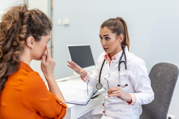 Young female professional doctor physician consulting patient\
talking to adult woman client at medical checkup visit diseases\
treatment medical health care concept