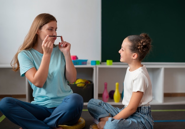 young female psychologist helping a girl in speech therapy