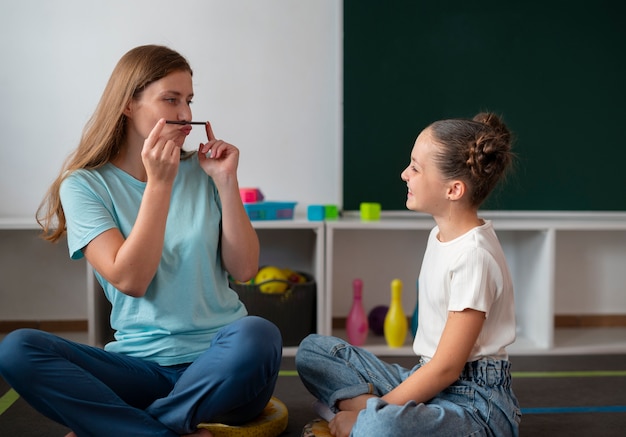 Photo young female psychologist helping a girl in speech therapy