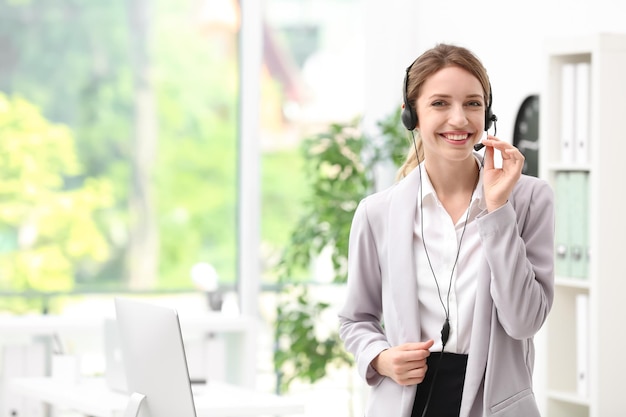 Young female receptionist with headset in office