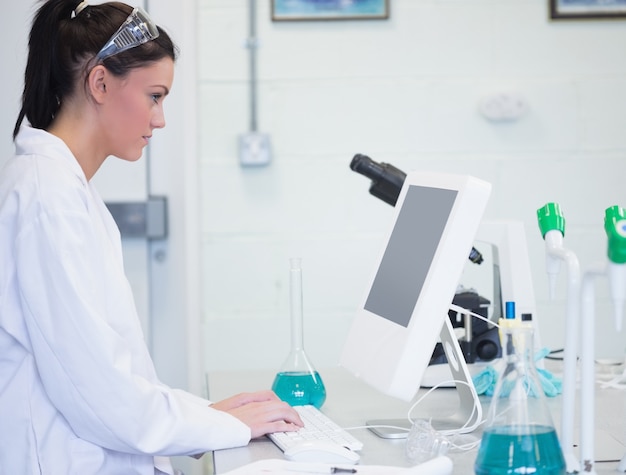 Young female researcher using computer in lab