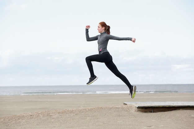 Молодая женщина бегун прыгает на открытом воздухе
