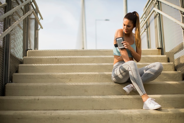 Young female runner resting on the stairs