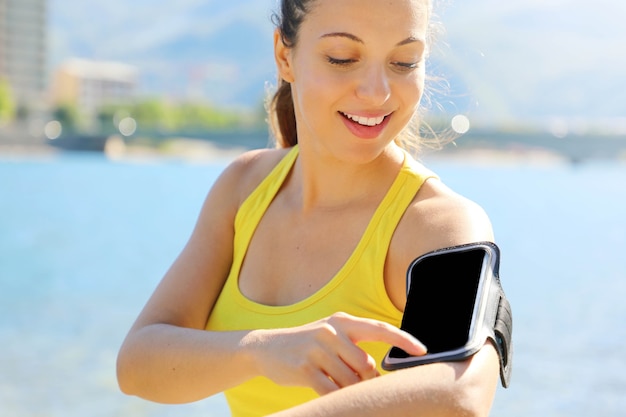 Young female runner wearing smart phone armband blank